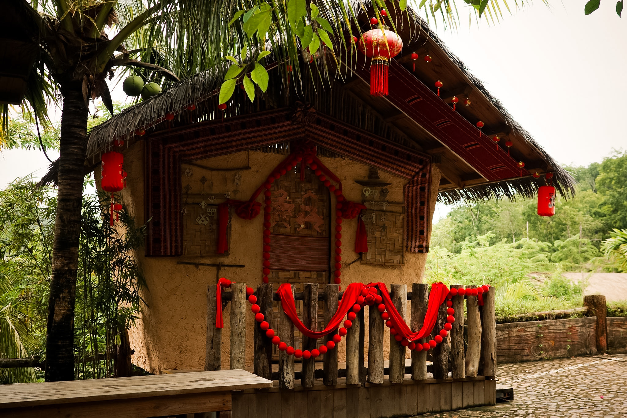 The longhui courtship house at Binglanggu, its mud walls hung with red lanterns and red cloth.