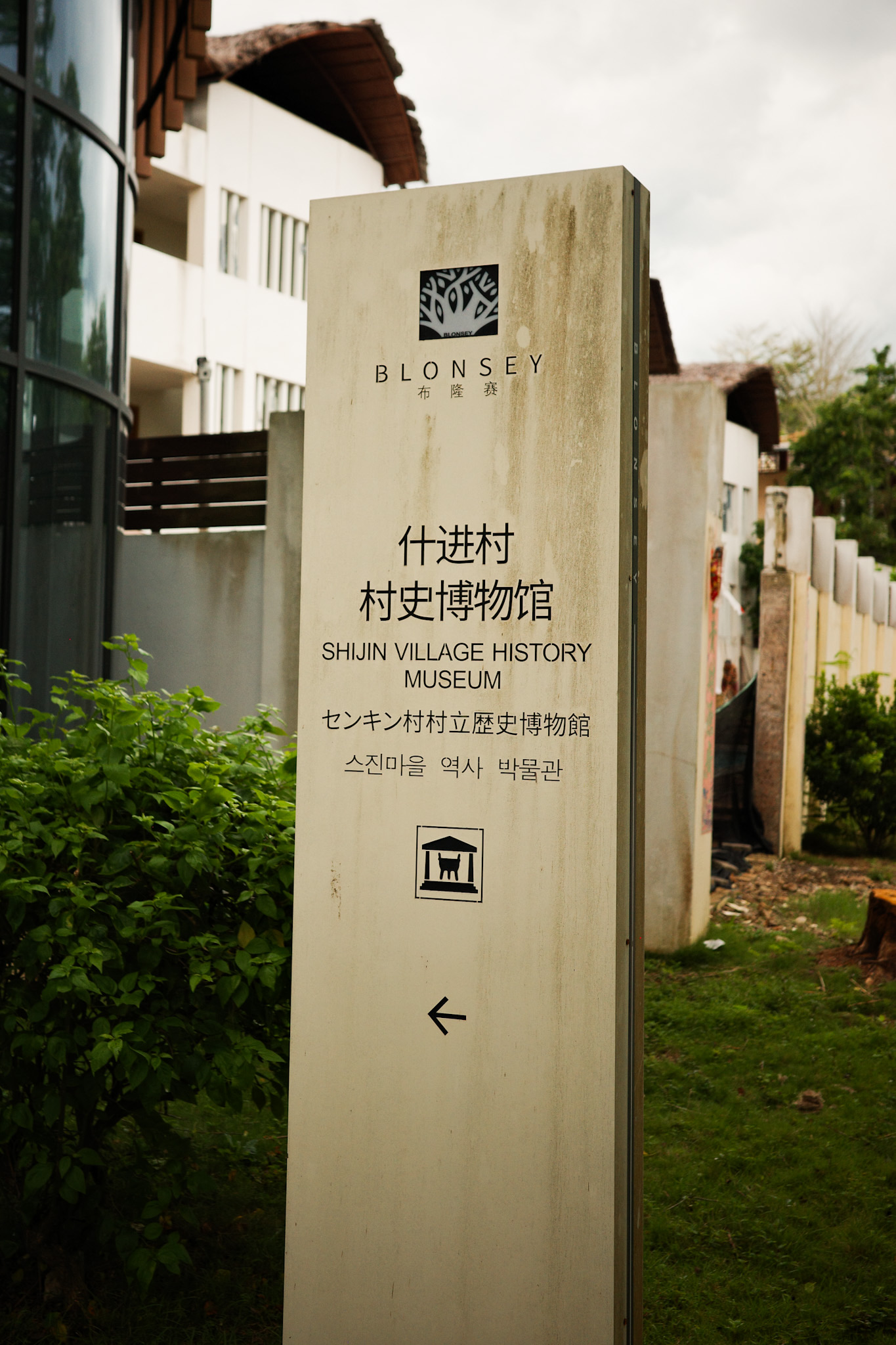 A faded and peeling sign at the museum entrance in Bulongzhai.