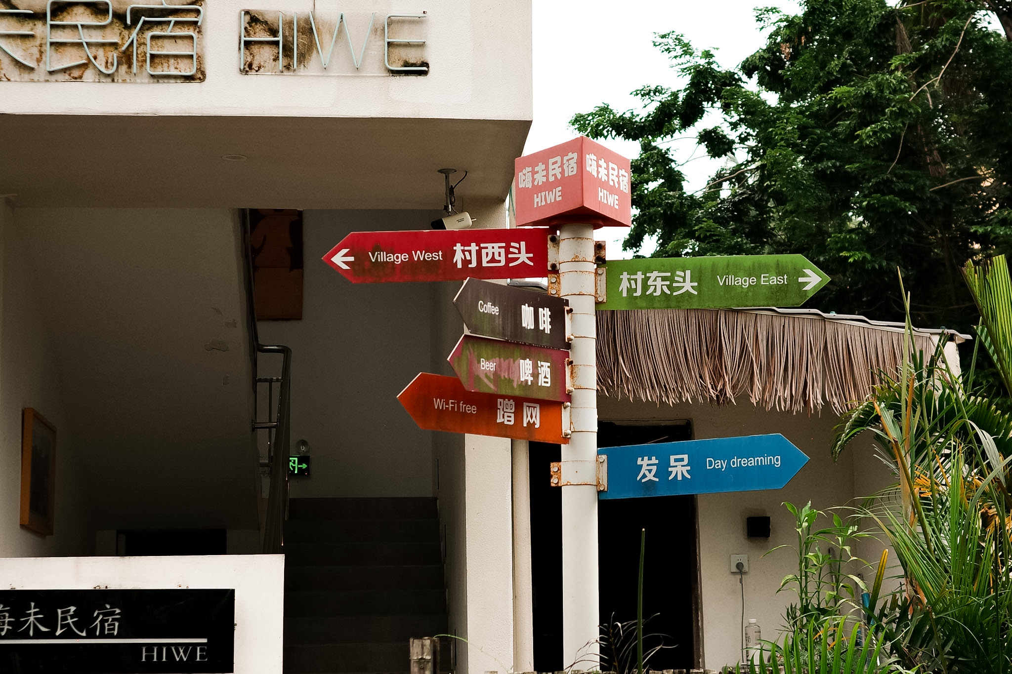 A guesthouse signpost standing beside a village road in Zhongliao.